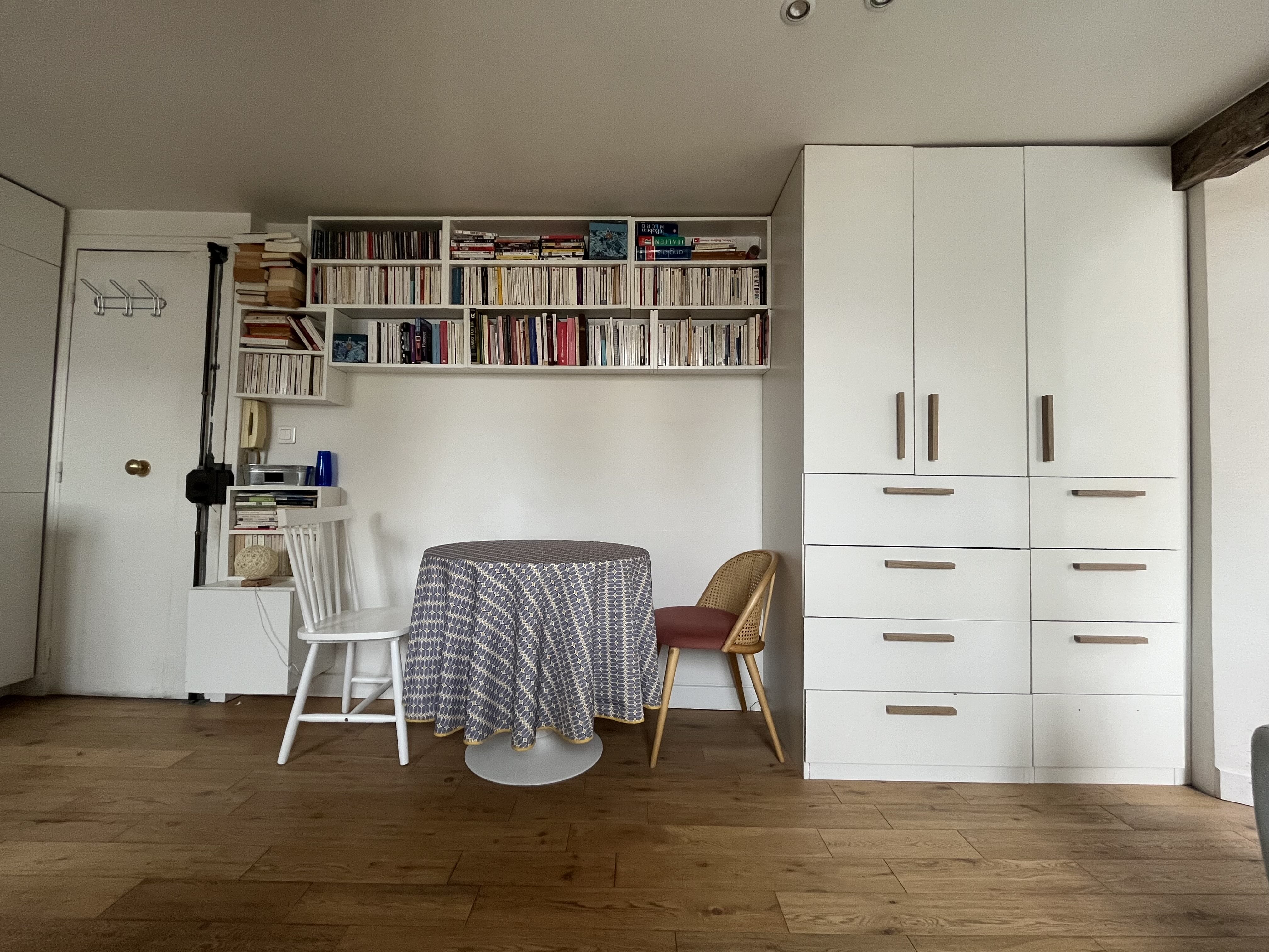 Round dining table, bookshelves and storage cupboards